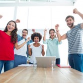 Happy business team with fists in the air at office