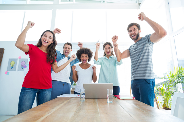 Happy business team with fists in the air at office